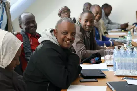 Adane Dechassa Teshale sits with a group of KAICIID Fellows