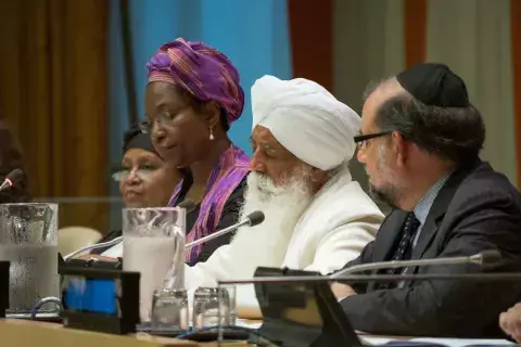 Four religious leaders sit together at table 