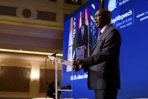 Adama Dieng stands at podium and speaks to audience at the KAICIID Power of Words Conference